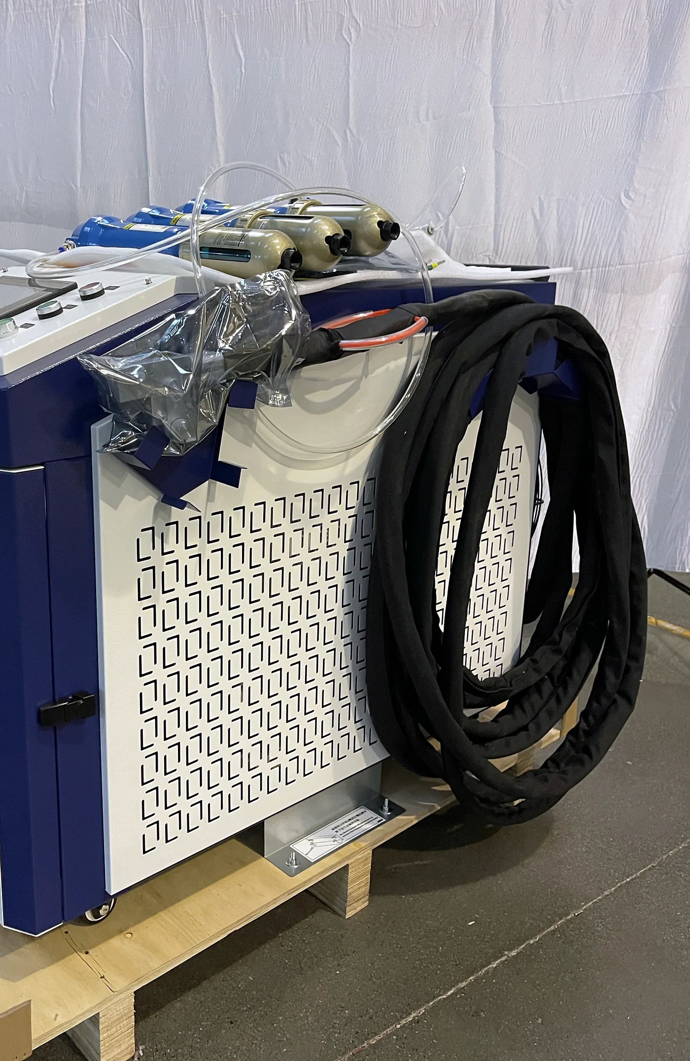 Side view of the Laserhi cleaning machine showing the perforated ventilation panel and coiled umbilical