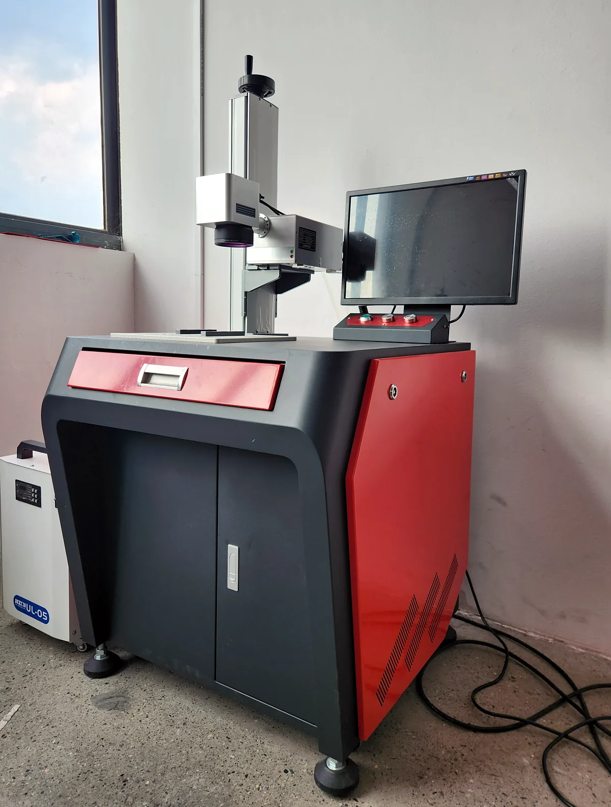 Laserhi cabinet-style UV laser marking machine installed on the shop floor with its chiller
