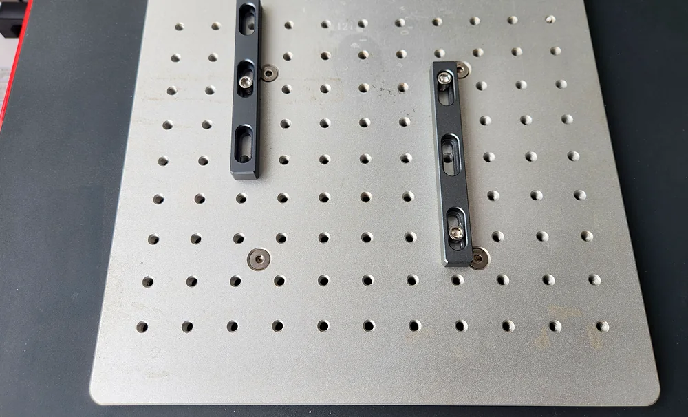 Close-up of the drilled and slotted marking work table with two steel clamping rails