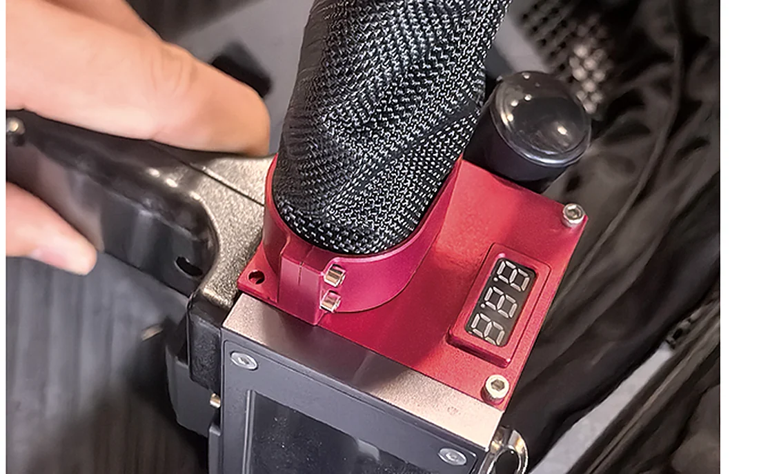 Handheld laser cleaning head working on a metal part