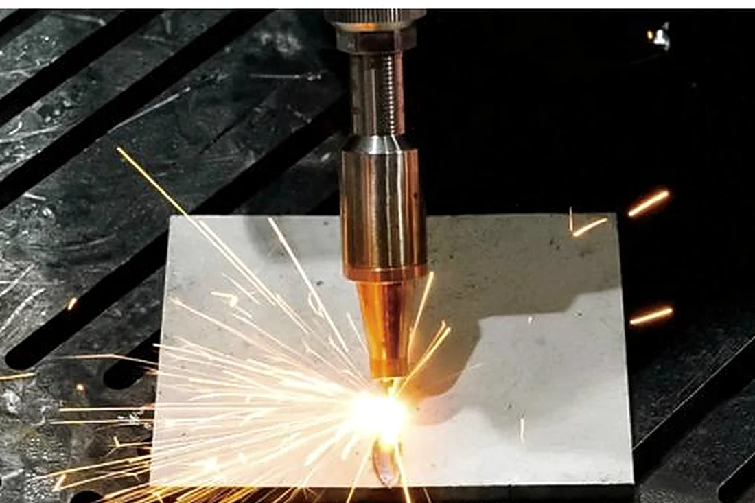 Fiber laser cutting a metal plate with a shower of sparks